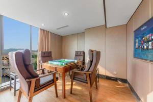 a room with a table and chairs and a large window at Chengdu Nine Point Art Hotel in Chengdu