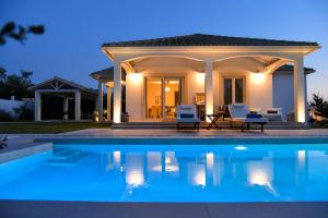 a villa with a swimming pool at night at Villa Evanna in Lefkimmi
