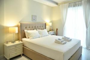 a bedroom with a large white bed with towels on it at Villa Evanna in Lefkimmi