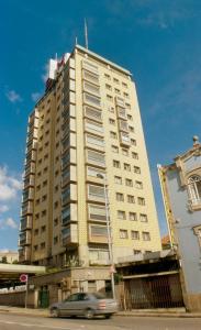 a car driving in front of a tall building at Hotel Miradouro in Porto