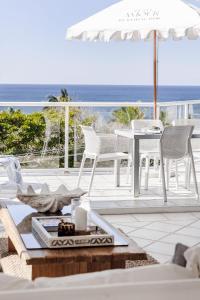 a patio with a table and chairs and the ocean at Hydra - 3 Bedrooms, Ocean views, Pool in Sunshine Beach