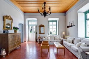 a living room with white furniture and a wooden ceiling at Orloff Resort in Spetses