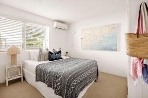 a white bedroom with a bed and a window at Hydra - 3 Bedrooms, Ocean views, Pool in Sunshine Beach
