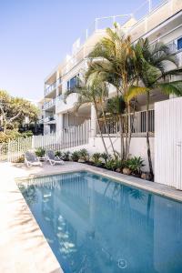 a swimming pool in front of a building at Hydra - 3 Bedrooms, Ocean views, Pool in Sunshine Beach