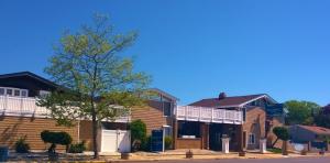 a row of houses with a tree in front of them at Atlantic Motel in Point Pleasant Beach