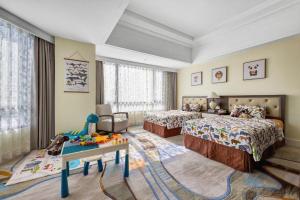 une chambre avec deux lits et une table dans l'établissement Hainan Junhua Haiyi Hotel, à Haikou 176 autres photos