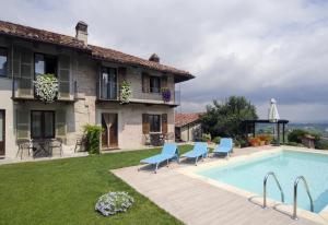 a house with a swimming pool and blue chairs at Sul Bric Dei Capalot in La Morra