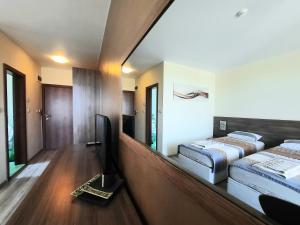 a room with two beds and a flat screen tv at Family hotel Delfa in Chernomorets