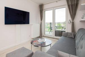 a living room with a couch and a glass table at Rezydencja Wrocław Legnicka in Wrocław
