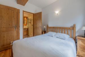 a bedroom with a white bed and a bathroom at Terrasse Bec Rouge Montroc - Happy Rentals in Chamonix-Mont-Blanc