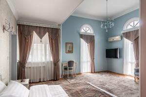 Prestige Palace - Esquisse Hotel في تبليسي: غرفة نوم بسرير وطاولة في غرفة