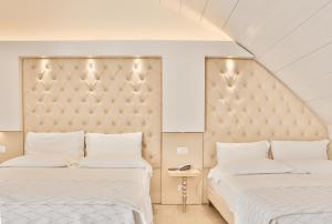 two beds sitting next to each other in a bedroom at Hotel Ambassador in Rimini