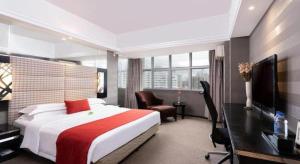 a bedroom with a bed and a desk and a television at Nanning Sanzan Hotel in Nanning