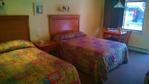 a hotel room with two beds and a table at Atlantic Motel in Point Pleasant Beach