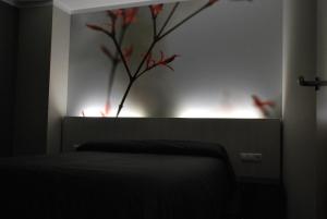 a bedroom with a vase with a plant on the wall at Aparthotel Meseguer in Alcañiz