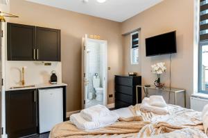 ロンドンにあるSimply Charming Studio Great Location 6のベッドルーム1室(ベッド2台、シンク付)、バスルーム1室が備わります。