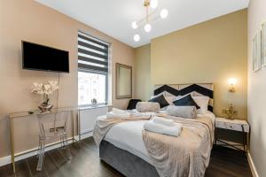 ロンドンにあるSimply Charming Studio Great Location 6の大きなベッドと薄型テレビのある寝室