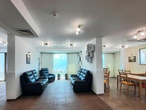 a living room with couches and a dining room at Family hotel Delfa in Chernomorets