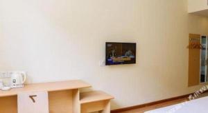 ein Wohnzimmer mit einem Fernseher an der Wand in der Unterkunft 7 Days Inn Tianjin Zhongshan Road North Station in Tianjin + 36 Fotos