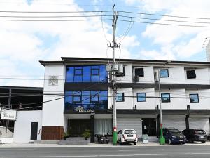 a white building with cars parked in front of it at Terra Hotel Kawit in Kawit