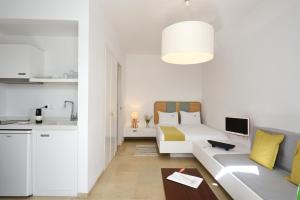a white living room with a couch and a kitchen at Orloff Resort in Spetses
