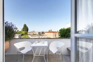 a white table and white chairs on a balcony at Orloff Resort in Spetses
