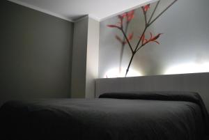 a bedroom with a bed with a vase on the wall at Aparthotel Meseguer in Alcañiz