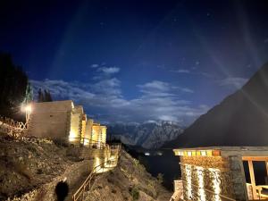 a building on a mountain at night with a view at Bucolic River Resort in Gulmit