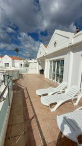 a patio with lounge chairs on the roof of a house at Exclusive Master Apartment in Adeje +34 photos