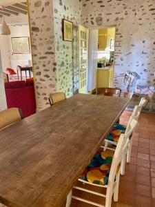 a dining room with a wooden table and chairs at Cottage authentique et chaleureux entre Pau et Lourdes pour 7 personnes in Nousty