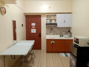 a kitchen with a table and a red door at A Scandinavian Staycation - ROMA 1616 in Mactan Island