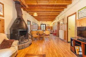 Una sala de estar con chimenea y un sofá. en El Torrent, en Pinell de Solsonès