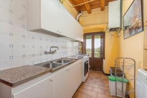 Una cocina con gabinetes blancos y un fregadero. en El Torrent, en Pinell de Solsonès
