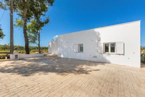 een wit gebouw met een stenen oprit bij Villa Surya by Perle di Puglia in Ugento