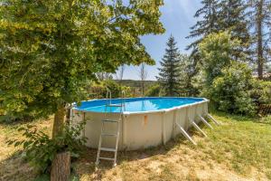 una bañera de hidromasaje en un campo junto a un árbol en El Torrent, en Pinell de Solsonès
