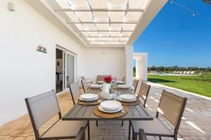 een eetkamer met een tafel en stoelen op een terras bij Villa Surya by Perle di Puglia in Ugento