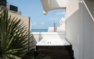 a bathroom with a bath tub and a plant at Hotel Ambassador in Rimini