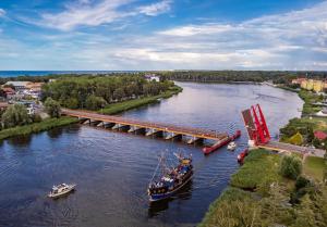 a boat is docked next to a bridge at Mieszkanie Ratownika in Dziwnów