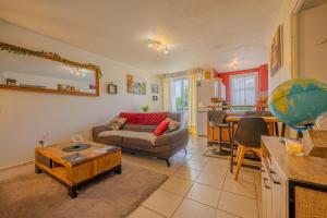 a living room with a couch and a table at Appartement Cosy - Résidence avec Parc et Piscine in Marans