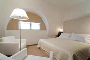 1 dormitorio con 1 cama, 1 silla y 1 ventana en Hotel Alzinn, en Luxemburgo