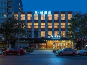 un bâtiment avec des voitures garées devant dans l'établissement James Joyce Coffetel Beijing Pinggu Hospital Century Square, à Yuegezhuang