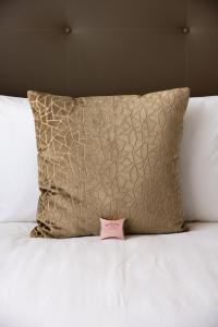 a pink price tag on a bed with a pillow at Kyalami Creek in Midrand +23 photos