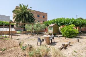 a backyard with a table and chairs and a playground at Casa Pont in Tarragona