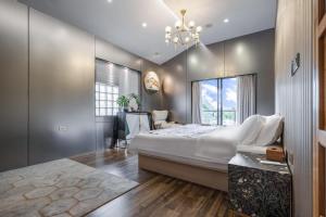um quarto com uma cama grande e um lustre em Guilin Tranquil Peaks Retreat by Reed Flute Cave em Guilin