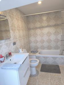 ein Badezimmer mit Waschbecken, Toilette und Badewanne in der Unterkunft Engy2 in Lens
