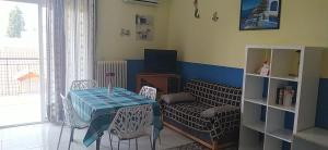 a living room with a table and chairs and a television at Mouses-X in Nea Kallikrateia