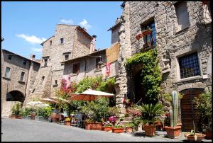 a stone building with an umbrella and some plants at La Casina Nel Borgo in Viterbo