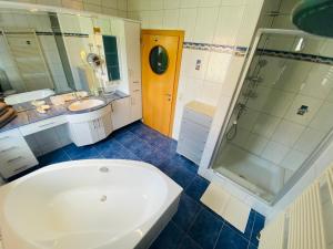 a bathroom with a tub and a sink and a shower at Villa Mira in Klopein am Klopeiner See +44 photos
