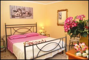 ヴィテルボにあるLa Casina Nel Borgoのベッドルーム1室(ピンクのシーツと花のベッド付)