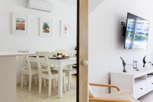 un comedor blanco con una mesa y sillas blancas en Vista Roses Mar - Casa Pescador, en Empuriabrava